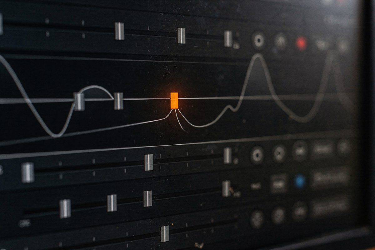 A close crop of an effects-rack panel with sliders and a frequency curve, one slider glowing orange