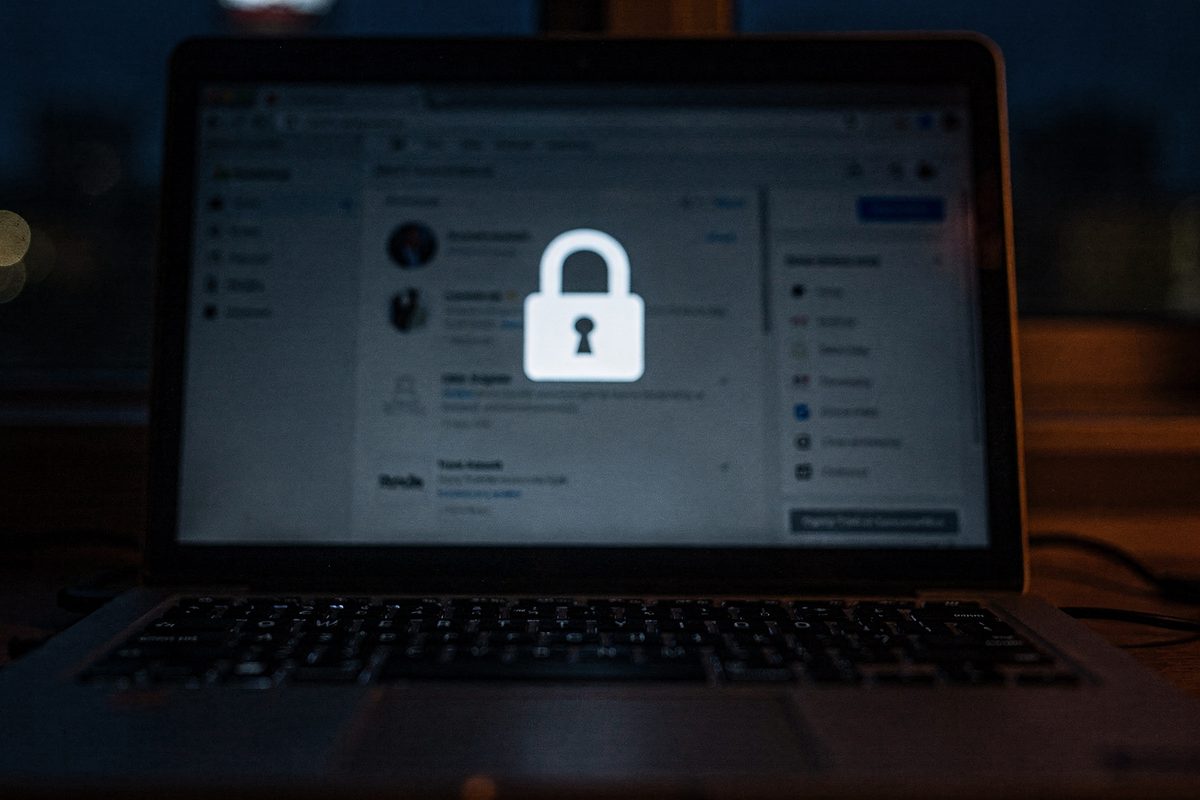 A laptop screen showing a padlock icon over a blurred settings panel